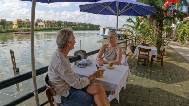 istock Mature couple enjoy beverage at outdoor cafe 1945746098