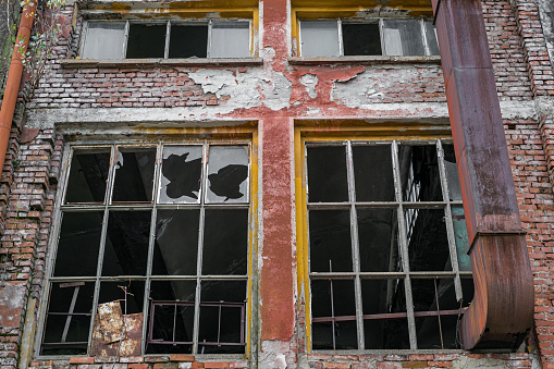 old decaying building with broken windows, close view