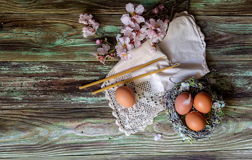 The easter composition. Two candles, almond branches and a eggs on wooden table close-up.