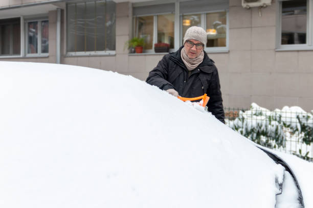 istock A mature man cleaning snow from car windshield outdoors on winter day. 1945813530