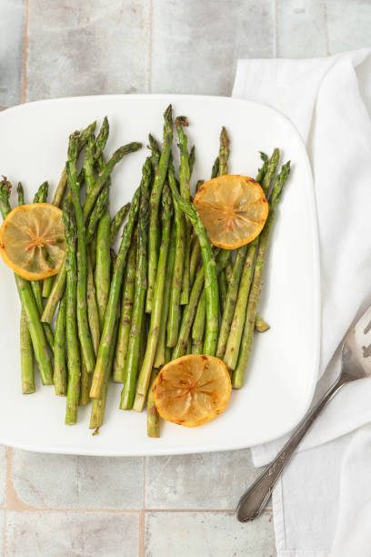 istock Top View of Grilled Asparagus with Lemon on a White Plate 1945833211