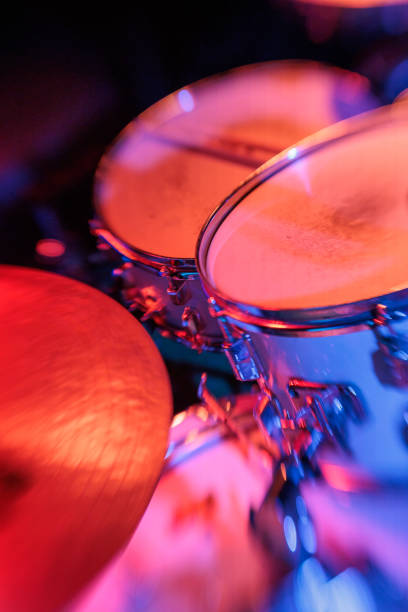 Close-Up of Drum Kit on Stage with Vibrant Red Lighting - Live Music Performance Equipment stock photo