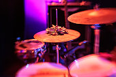 Drum Kit with Hi-Hat on Stage in Vibrant Red stage Light ready for live music performance