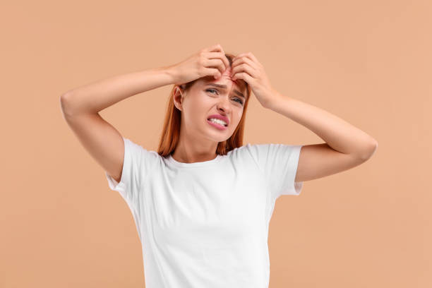 istock Suffering from allergy. Young woman scratching her face on beige background 1945840424