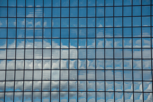 The reflection of the sky and clouds combine with the grid window layout of 180 Maiden Lane to form an abstract image.