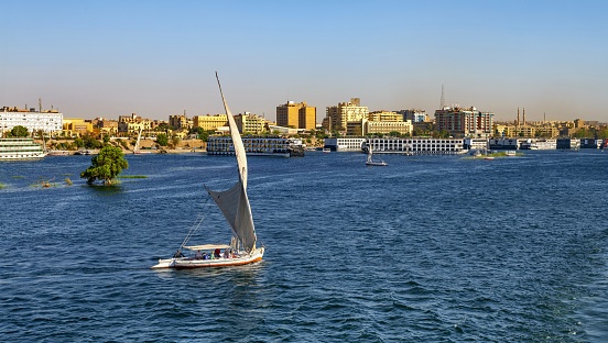 Aswan, Egypt, April 13, 2023: A boat sails on the Nile River in the city of Aswan on a sunny spring day.
