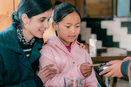 Youth makes contactless payments in a restaurant through a Wi-Fi debit card.