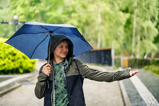 Teenage boy enjoying heavy rain\nShot with Canon R5