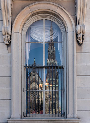 The historic Mount Vernon Methodist Church is reflected in a window of the 1878 Peabody Institute in the Mount Vernon neighborhood of Baltimore.