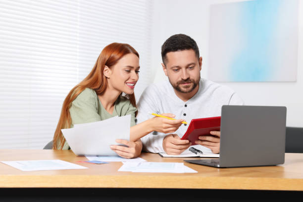 istock Couple calculating taxes at table in room 1945877277