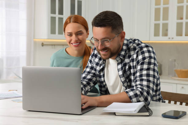 istock Couple using laptop for paying taxes at home 1945878334