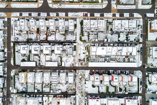 Residential neighborhood in the snow, viewed from directly above.