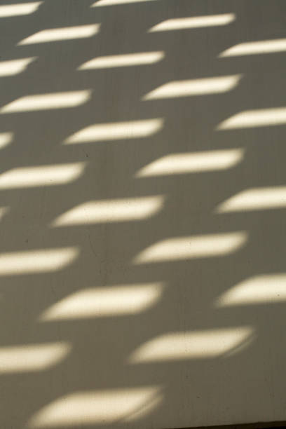 Light patterns on a white textured wall background stock photo