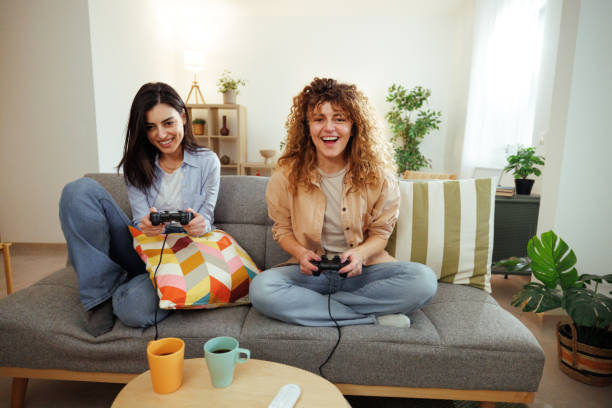 istock Competitive women playing console and having fun at home 1945917514