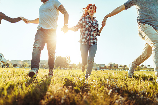 Group of friends in a city park, enjoy a warm spring sunset together