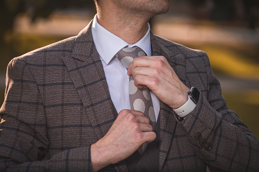 Businessman in formal clothes adjusting his necktie