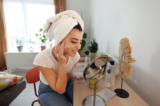 istock Smiling woman applying face cream 1945934260