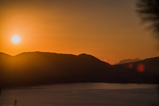 beau coucher de soleil orange sur la mer et les montagnes - horizon over water horizontal surface level viewpoint photos et images de collection