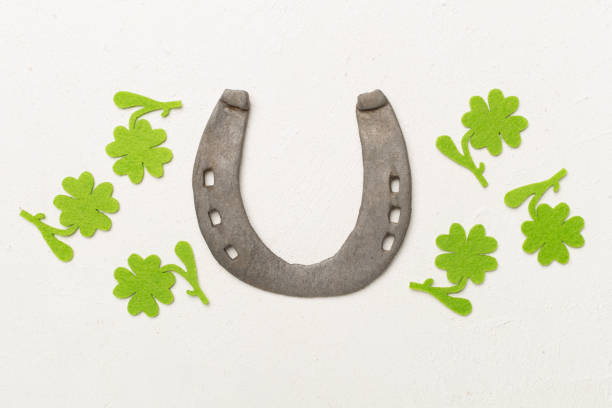 Horseshoe with clover on concrete background, top view. St. Patricks day concept