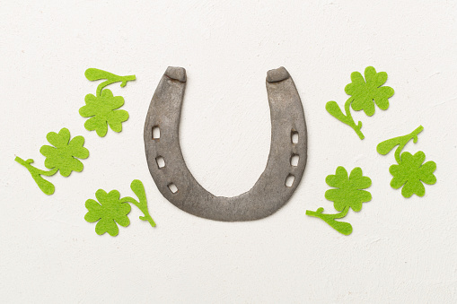Horseshoe with clover on concrete background, top view. St. Patricks day concept
