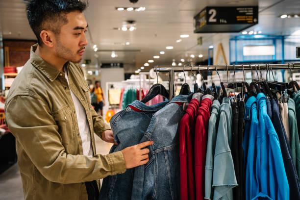 istock Man Contemplating Denim Jackets in a Store 1945974034