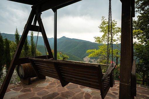 Picturesque mountain view from a wooden swing, inviting relaxation and contemplation.