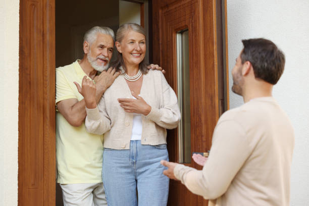 istock Friendly relationship with neighbours. Man visiting elderly couple 1945980823