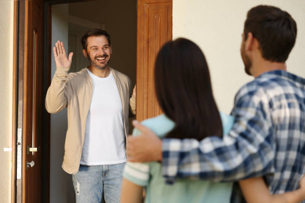 istock Friendly relationship with neighbours. Young couple visiting happy man 1945981345