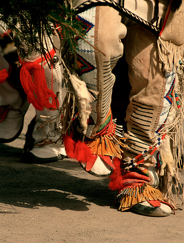 Native American dancers from New Mexico Pueblos dance in ceremonial traditions. The buckskins and moccasins are shown as the dance to the rhythm of the drums and singing.