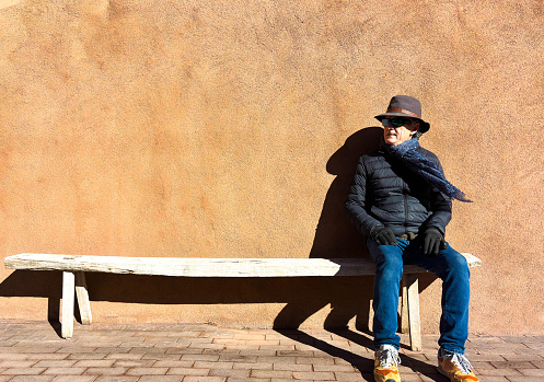 Southwest USA: Man in Hat Against Sunny Adobe Wall