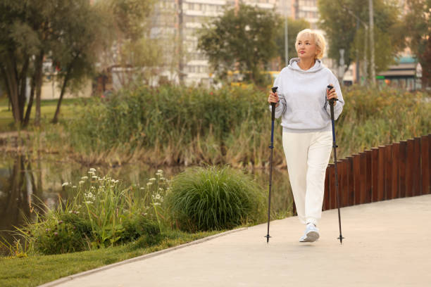 istock Senior woman performing Nordic walking outdoors, space for text 1946090557