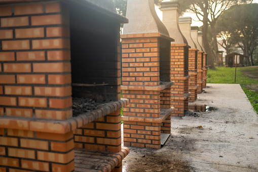 Public BBQ used for outdoor cooking. Outdoor cooking structure built using. Red brick barbecues consisting of solid foundation made from red bricks. Selective focus