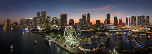 Miami marina harbor and skyscrapers of Brickell, city financial center. Skyviews Miami Observation Wheel at Bayside Marketplace with reflections in Biscayne Bay water and US urban landscape at night. el puerto deportivo de miami y los rascacielos de brickell, centro financiero de la ciudad. rueda de observación skyviews miami en bayside marketplace con reflejos en el agua de la bahía de biscayne y el paisaje urbano de ee. uu. por la noche