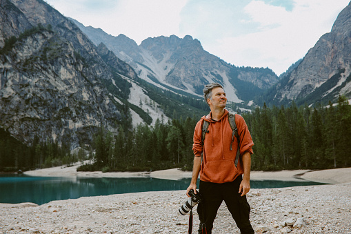 Photographer traveling the Italian Alps, taking beautiful photos next to the Lago di Braies in Dolomites.