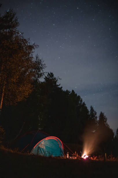 istock Camping - camp tent  and fire in forest at night 1946166471