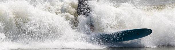 istock Surfer trying to stay up riding rough water waves 1946180081