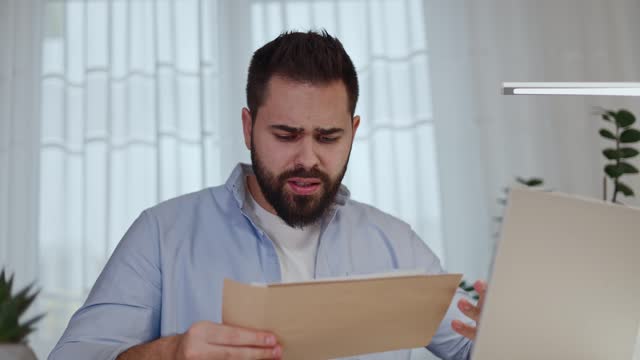Curious guy receiving mail in paper envelope with disappointing message and expressing frustration with facepalm gesture. Young entrepreneur getting loan denial for startup business development.