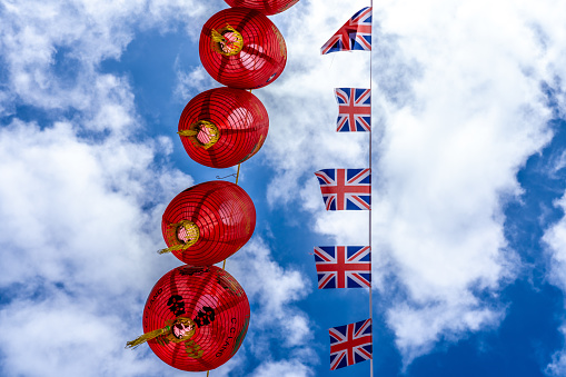 London England - May 29 2023: Chinese Lanterns and Union Jack Flags Against the Sky in Chinatown London United Kingdom