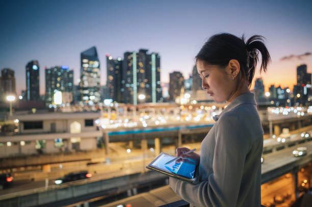 istock An Asian female Investment Banking Analyst drawing planning statistics graphs on screen on digital tablet 1946361631