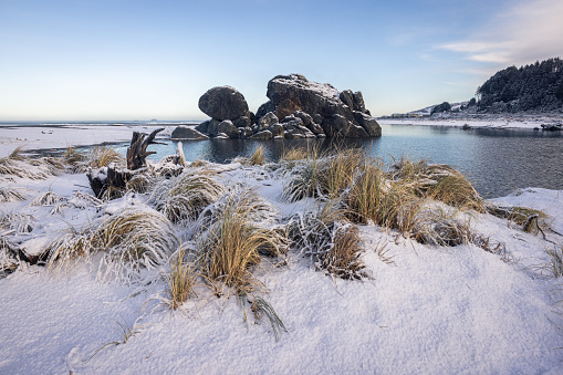 Popular rock feature in Gold Beach Oregon known as turtle rock covered with snow in a rare winter storm in February 2023