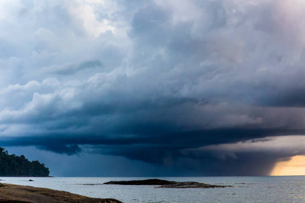 Huge offshore thunder storm and rain at sunset over a tropical ocean