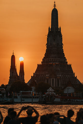 Bangkok, Thailand - January 12,2023: 
Tourists take photos of Wat Arun (Temple of Dawn) and the Chao Phraya River during a beautiful sunset in Bangkok. Thailand.