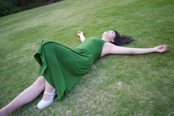 Low angle view of happy young Caucasian woman holding scarf at beach on sunny day. She seems relaxed