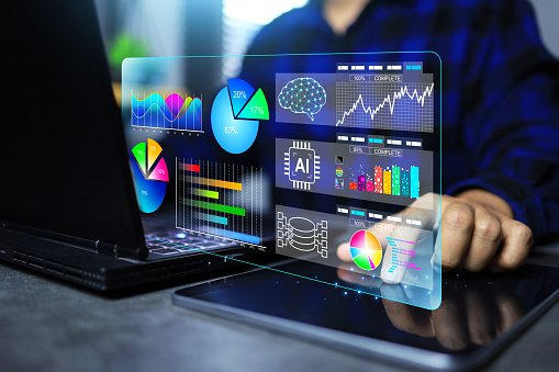 Data analysis concept with programmer or developer touch on tablet screen to analyse business information on graph and chart display on laptop screen by using ai to help as assistance analytic