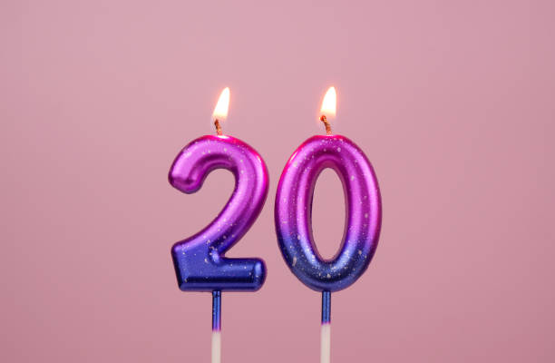 istock Pink and blue birthday candles on pink, number 20. 1946660196