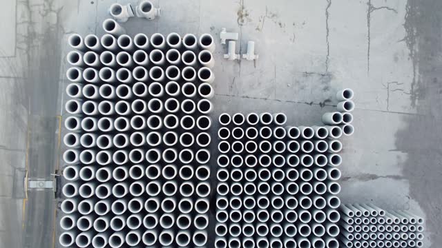 Aerial view of stacked industrial pipes in a storage yard, showcasing patterns and repetition.