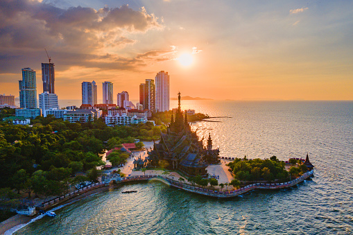 Skyline of Pattaya city at sunset with The Sanctuary of Truth wooden temple in Pattaya Thailand