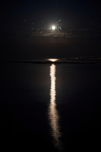 View of the sea and the moon at night. Moonlight path on the water