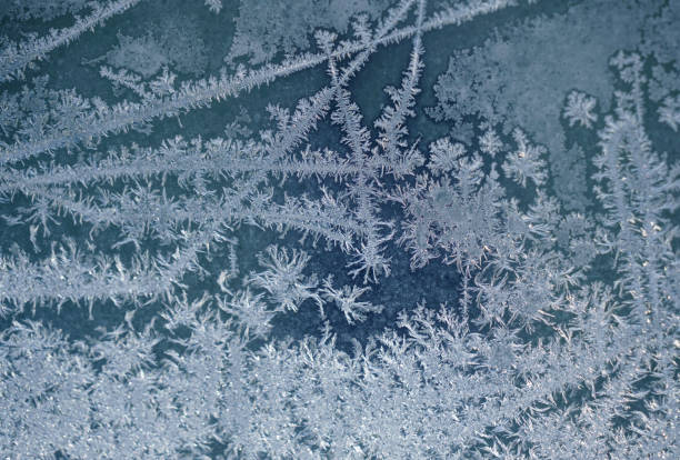 frost crystal on window glass in winter season - frosted glass glass textured crystal stock-fotos und bilder