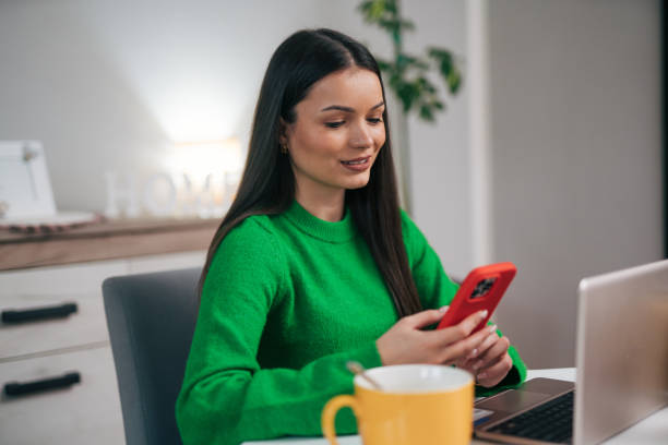 istock Attractive woman talking with friends while having breakfast in the kitchen 1946873978